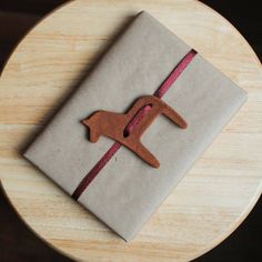 a wrapped present sitting on top of a wooden table next to a brown dog ornament