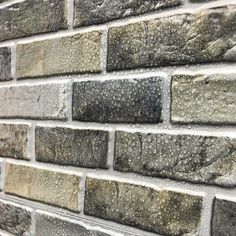 a brick wall that is made out of grey bricks and has some water droplets on it