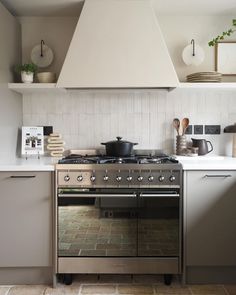 a stove top oven sitting inside of a kitchen next to a wall mounted range hood