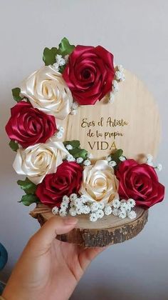 a hand holding a wooden box with roses on it