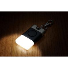 a light that is sitting on top of a wooden table next to a keychain