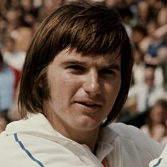 a man holding a tennis racquet in front of a crowd