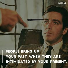 a man sitting in a chair with a hand pointing at him and the caption reads, people bring up your past when they are intimateized by your present