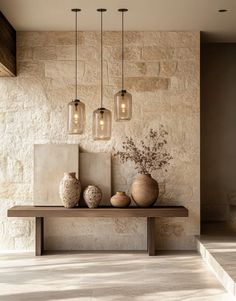 some vases are sitting on a table in front of a stone wall with lights