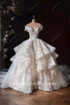 a white wedding dress on display in front of a black background