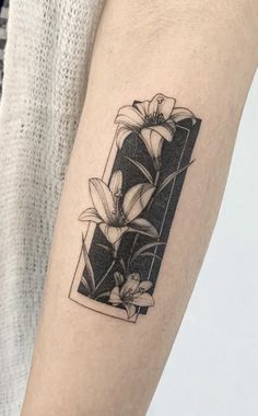 a tattoo on the arm of a woman with flowers in a black and white frame