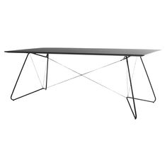 a black table sitting on top of a white floor next to a metal frame structure