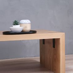 a wooden table with a bowl on it and a succulent plant sitting on top