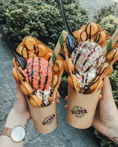 two ice cream cones with sprinkles and toppings