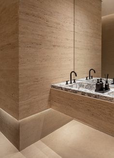 a bathroom with two sinks and marble counter tops on the wall next to each other