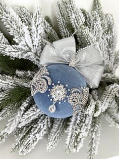 a blue ornament with silver bows and snowflakes on it's side