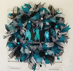 a blue and black wreath on the front door is decorated with an image of two women