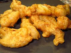 some fried chicken pieces on a black plate