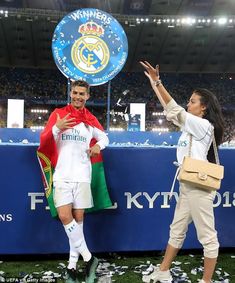 two women standing next to each other at a soccer game