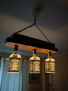 three bottles are hanging from a light fixture