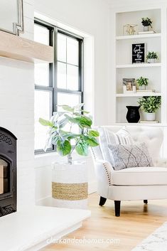 a living room with white furniture and a fireplace