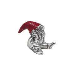 a silver brooch with a red hat on it's head and hands holding something