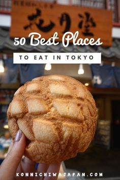 a person holding up a pastry with the words 50 best places to eat in tokyo