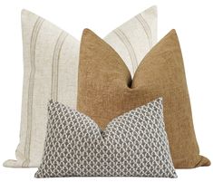 three pillows with different patterns on them, one is brown and the other is white