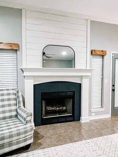 a living room with a fire place and a chair next to an open door that has shutters on both sides