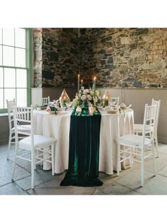 the table is set with white and green linens