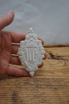 a person holding a small white object with the letter w in it's center