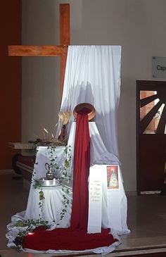 the altar is decorated with white linens and red ribbon, along with other items