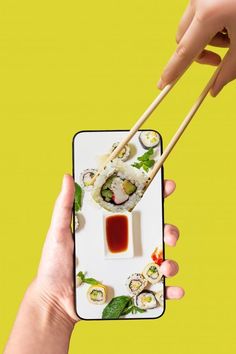 a person holding up a phone case with sushi and chopsticks on it