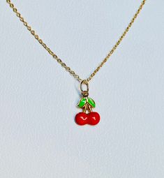 "A beautiful 14K solid yellow gold Red Cherry puffy charm / pendant with hand painted and baked enamel. It has a soldered ring to attach to a bracelet or a necklace. The small pendant measures 10mm (0.39\") tall with bail and without the soldered ring and 7.3mm (0.29\") wide. It can be used as a necklace pendant or a bracelet charm and would make a perfect gift. The pendant can be paired with a shiny 14K Yellow Gold 1.2mm cable link chain in either 16\" or 18\" length or with a 16\" 14K gold-pla Handmade Yellow Gold Enamel Necklaces, Handmade Yellow Gold Enamel Necklace, Cute Round Charms Jewelry, Red Enamel Round Pendant Necklace, Yellow Gold Enamel Round Pendant Charm Necklace, Cute Gold Jewelry With Charms, Adjustable Enamel Necklace For Gifts, Handmade Gold Charm Necklaces With Enamel, Handmade Gold Charm Necklace With Enamel