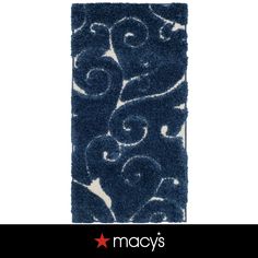 a blue rug with white swirls and stars on the bottom, in front of a black background