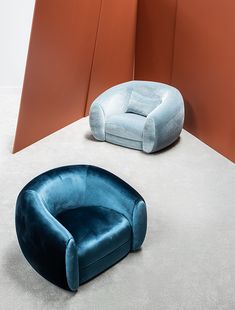 two blue chairs sitting next to each other on top of a floor