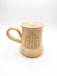 a coffee cup with an intricate design on the outside and inside, sitting on a white surface