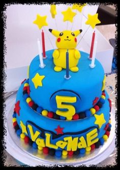 a blue birthday cake with yellow stars and a pikachu on top