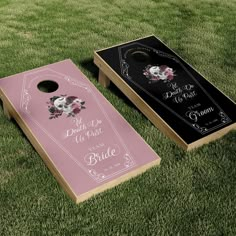 two pink and black cornhole game boards on the grass