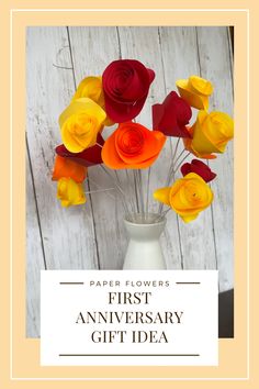 a vase filled with paper flowers on top of a wooden table