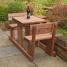 two wooden benches sitting next to each other with a bottle of wine on the table