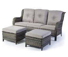 a wicker couch and ottoman with cushions