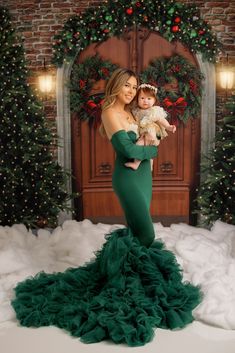 a woman in a green dress holding a baby