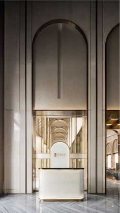 an empty lobby with marble flooring and arches on the walls, along with a white reception counter