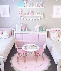 a room with two twin beds, pink chairs and a table in the middle of it