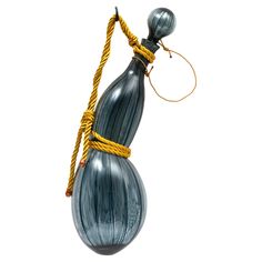 a blue glass vase with yellow rope hanging from it's side on a white background