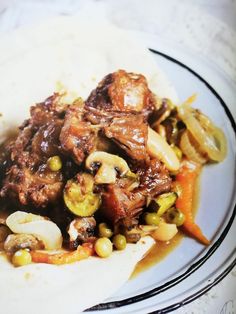 a white plate topped with meat and vegetables