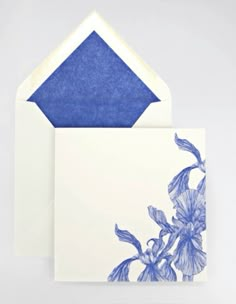 an envelope with a blue flower on the front and white envelope with a blue border