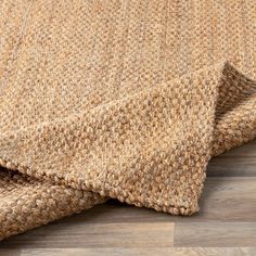 a close up view of a rug on the floor with wood floors in the background