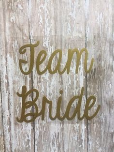 the word team bride is made out of metal on a wooden background with white paint