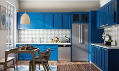 a kitchen with blue cabinets and wooden floors is shown in this image, there are two chairs at the table