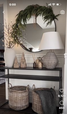 a shelf with baskets and lamps on top of it in front of a large mirror