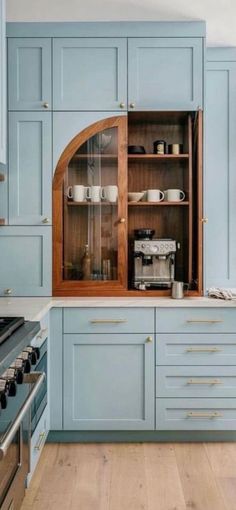 a kitchen with blue cabinets and wooden floors