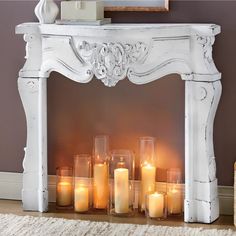 candles are lit in front of an ornate white fireplace mantel with carved carvings and scrolls