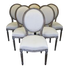 six chairs with white upholstered back and silver trimmings on each chair